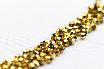 Beautiful golden glass beads closeup on white background