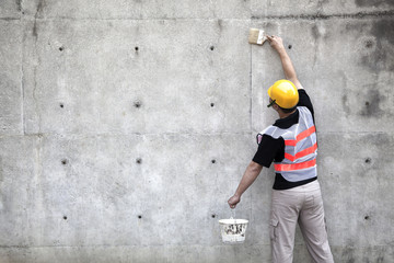 Obraz na płótnie Canvas painter working on the old concrete wall