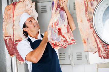 Butcher Looking At Raw Meat