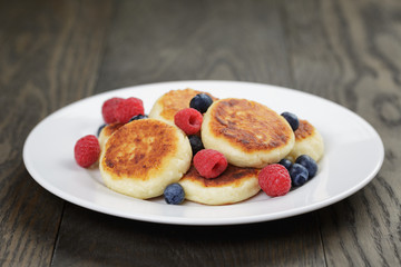 homemade curd fritters on plate with berries