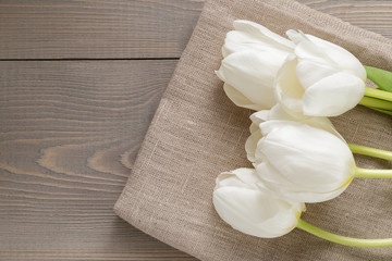 Fototapeta na wymiar white tulips on rustic wood background