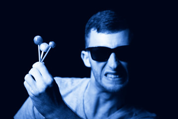 Agressive young man with lollipops in hand