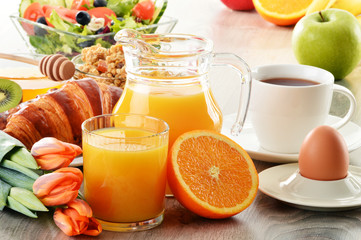 Breakfast with coffee, juice, croissant, salad, muesli and egg