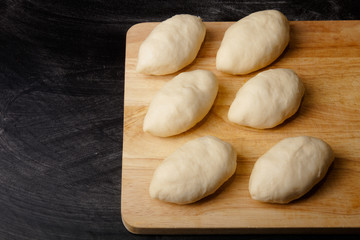 Fototapeta na wymiar Pieces of dough on the wooden board