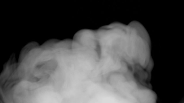 Smoke billowing over a black background. 4K UHD 2160p footage.