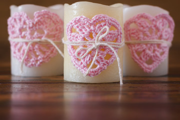 Three candles with handmade crochet pink heart for Saint Valenti