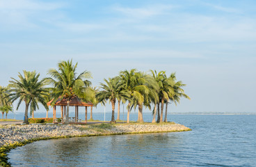 Fototapeta na wymiar Garden pavillion with coconut palm tree on the shore