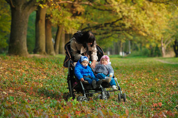mother with children twins on a walk in the autumn park