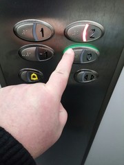 Mano apretando botón de un ascensor