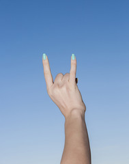 Hand up in the sky making sign of the horns