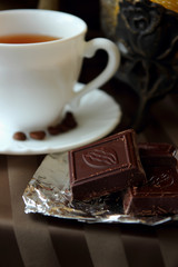 Cup of coffee and a chocolate bar.