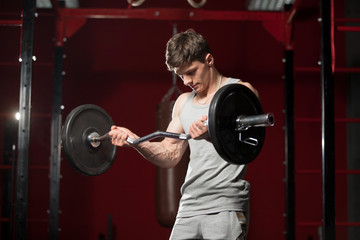 Fototapeta na wymiar Young man lifts weight in gym