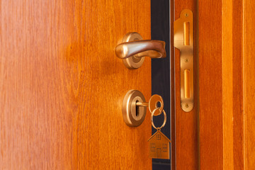 Obraz premium open door with inserted key in the keyhole and house icon on it
