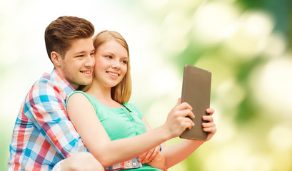 couple with tablet pc taking selfie over green