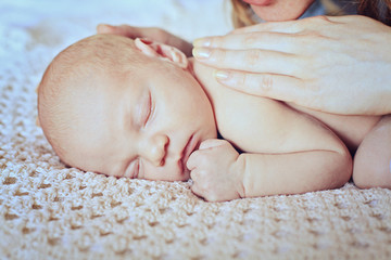 sleeping baby with mothers hand