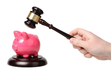 Hand with gavel beats on a piggy bank