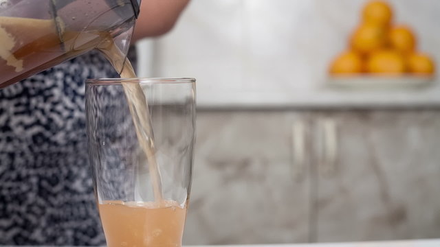 Fresh and cold apple juice against tasty poured into a glass