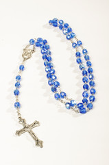 Blue rosary isolated on the bright background