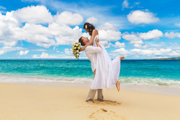 happy bride and groom having fun on a tropical beach © frolova_elena