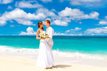 happy bride and groom having fun on a tropical beach