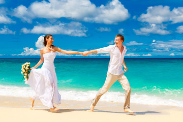 happy bride and groom having fun on a tropical beach