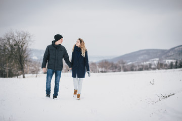 Young couple walking in a winter countryside