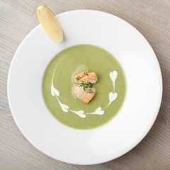 Green broccoli cream soup puree with filleted salmon  and  lemon