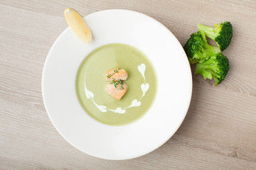 Green broccoli cream soup puree with filleted salmon  and  lemon