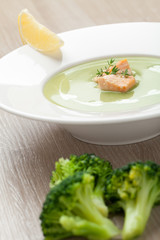 Green broccoli cream soup puree with filleted salmon  and  lemon