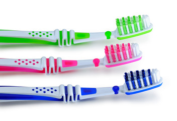 Blue, green, pink toothbrushes isolated on white background
