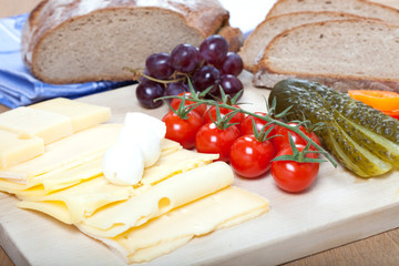 Bayrische Käse Brotzeit auf rustikalem Holzbrett