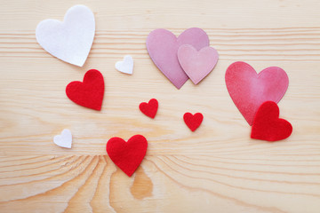 Assorted hand crafted hearts on natural wood background