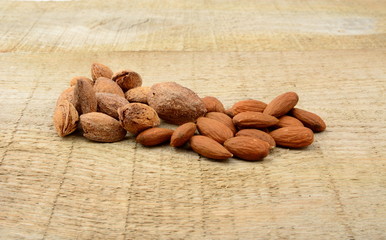 Group of almonds with shell on wooden plank,board