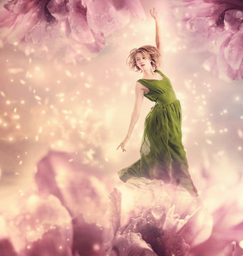 Beautiful woman jumping in a pink peony flower fantasy
