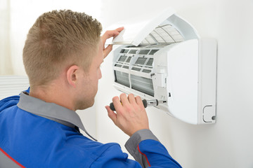 Obraz na płótnie Canvas Technician Repairing Air Conditioner