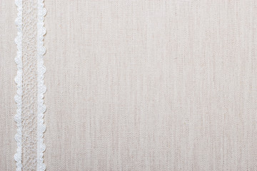 Lace ribbon on linen cloth background