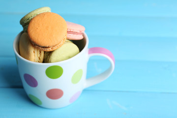 Assortment of gentle colorful macaroons in colorful mug