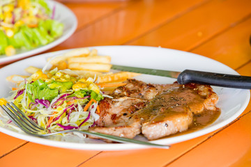 juicy grilled pork chop (neck cut) with salad