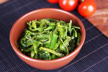 Seaweed salad in bowl with cherry tomatoes