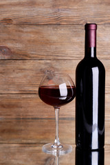 Red wine on table on wooden background