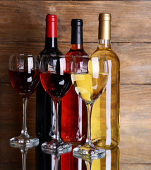 Different wine on table on wooden background