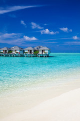 Water villas in the ocean and white sandy beach