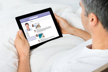 Man Chatting On Social Network Sites Using Digital Tablet