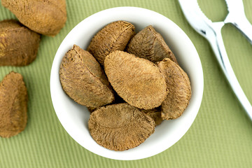 Brazil nuts in bowl with nut cracker