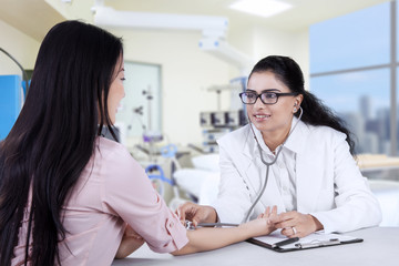 Fototapeta premium Asian doctor listening the patient heartbeat