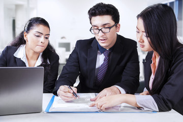 Businessman signing a contract with his partners