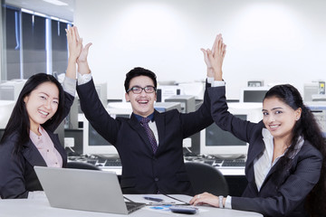 Cheerful business team toasting hands
