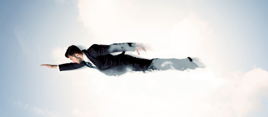 Business man flying like a superhero in clouds on the sky