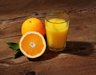 Ripe orange fruits and juice in glass