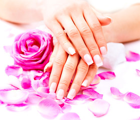 Obraz na płótnie Canvas Hands spa. Beautiful female hands with pink rose flowers petals